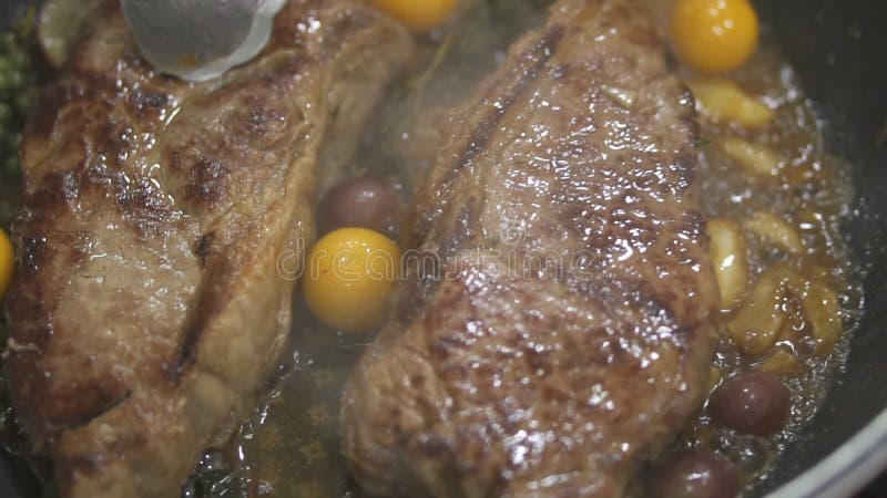Взгляд крупного плана очень вкусных стейков говядины помещенных на горячем гриле сток-видео