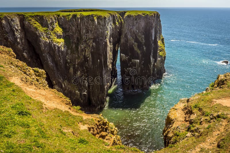 Взгляд между стогом утеса и материком на Pembrokeshire плавает вдоль побережья, Уэльс стоковые фотографии rf Взгляд между стогом утеса и материком на Pembrokeshire плавает вдоль побережья, Уэльс стоковые фотографии rf