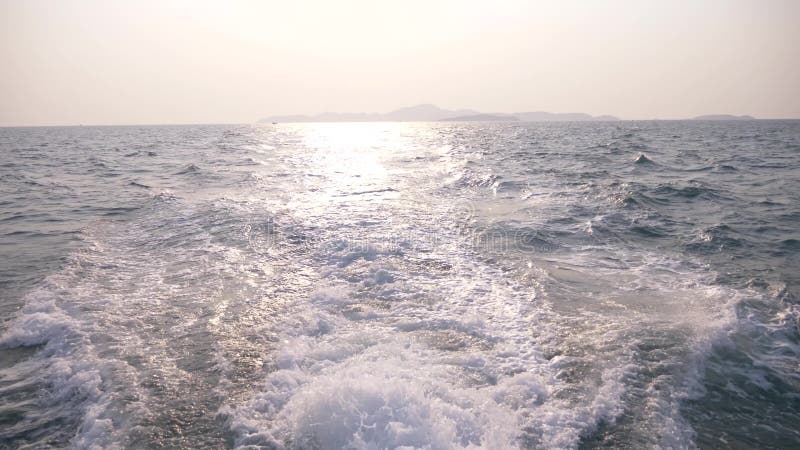 Взгляд моря от корабля ветрила корабля от острова на заходе солнца нерезкости стоковое фото Взгляд моря от корабля ветрила корабля от острова на заходе солнца нерезкости стоковое фото