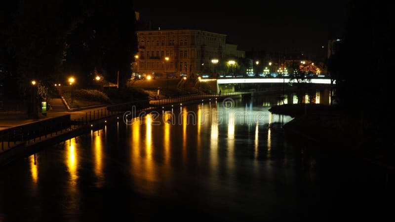 Взгляд ночи реки Brda и зданий старого городка в Bydgoszcz, с мостом на улице Mostowa стоковые изображения rf Взгляд ночи реки Brda и зданий старого городка в Bydgoszcz, с мостом на улице Mostowa стоковые изображения rf