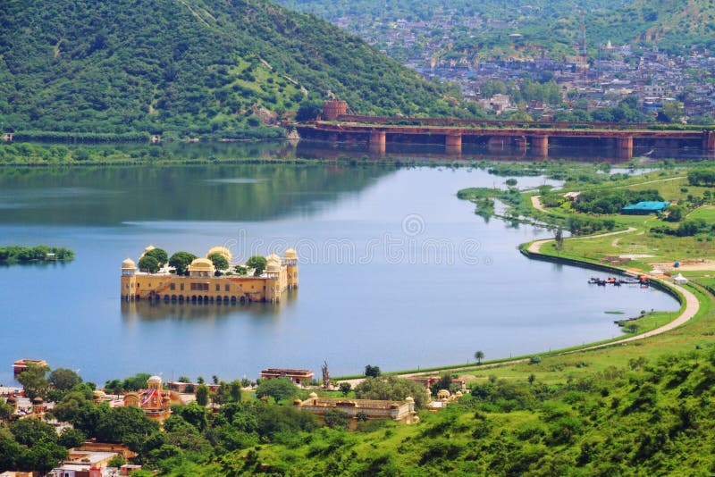 Top View Of Jaipur Jal Mahal in Man Sagar Lake with Man Sagar Dam in Background. Jaipur,Rajasthan,India. The Jal Mahal palace is considered an architectural beauty built in the Rajput and Mughal styles of architecture.The palace, built in red sandstone, is a five storied building out of which four floors remain under water when the lake is full and the top floor is exposed. Top View Of Jaipur Jal Mahal in Man Sagar Lake with Man Sagar Dam in Background. Jaipur,Rajasthan,India. The Jal Mahal palace is considered an architectural beauty built in the Rajput and Mughal styles of architecture.The palace, built in red sandstone, is a five storied building out of which four floors remain under water when the lake is full and the top floor is exposed.