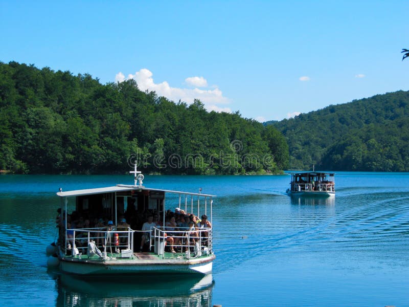 Взгляды лодки 2 плавая на озеро в озерах Plitvice национального парка, Хорватии стоковые изображения rf Взгляды лодки 2 плавая на озеро в озерах Plitvice национального парка, Хорватии стоковые изображения rf