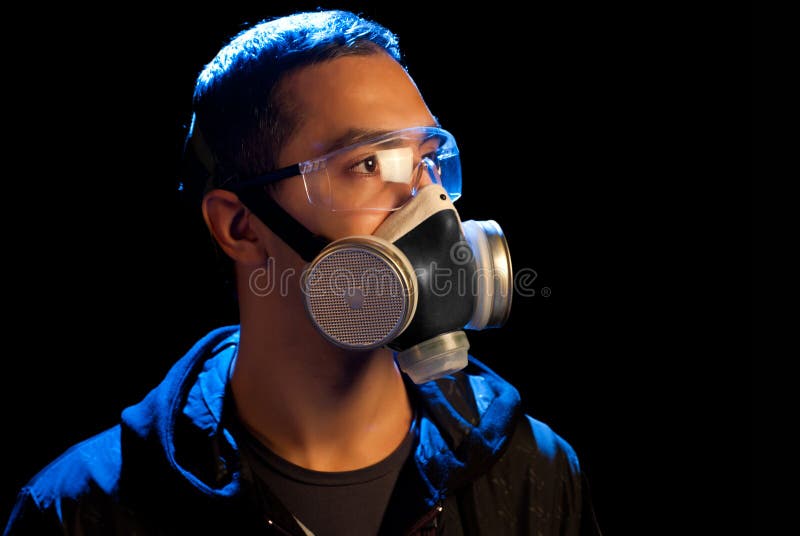 A man in a respirator and glasses. Isolated on black. A man in a respirator and glasses. Isolated on black.