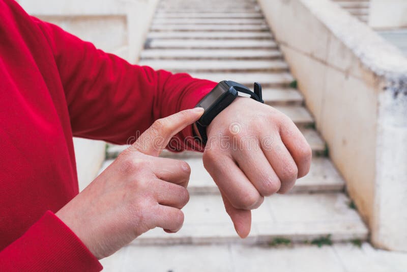 Взорвать застрелили в джинсовом женщины, проверяя ее пульс с smartwatch после учений стоковые фото