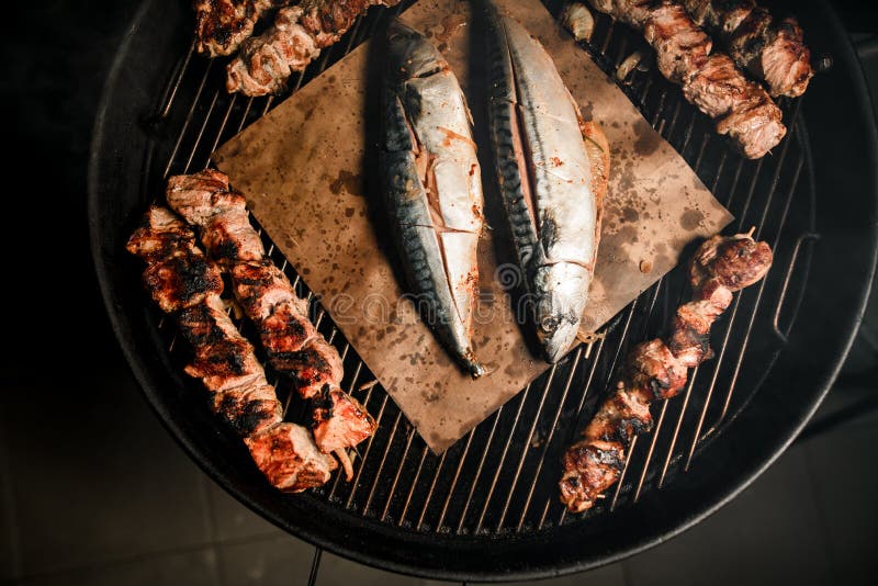 Взорвать решетки барбекю с частями жареного мяса и рыбы. стоковые изображения