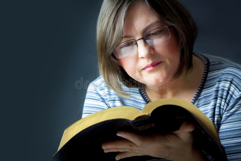 Adult Woman Reading a Bible. Close. Adult Woman Reading a Bible. Close