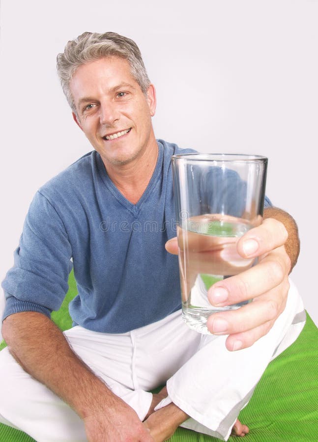 Mid adult man holding a glass of water. Mid adult man holding a glass of water.