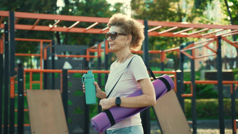 взрослая женщина ходит на занятия йогой на улице. активный старшеклассник наслаждается здоровым образом жизни. матч для женщин ста сток-видео
