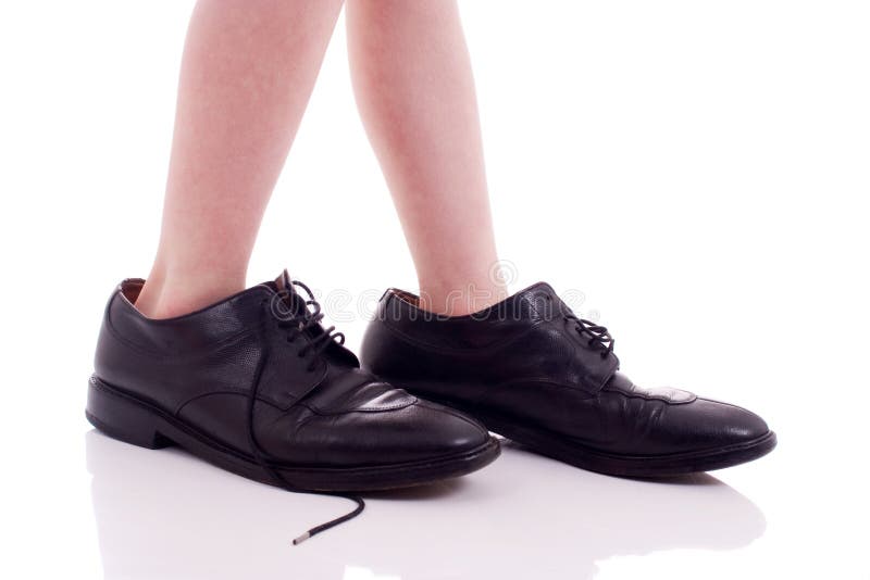 Child wearing adult shoes, isolated on white background. Child wearing adult shoes, isolated on white background