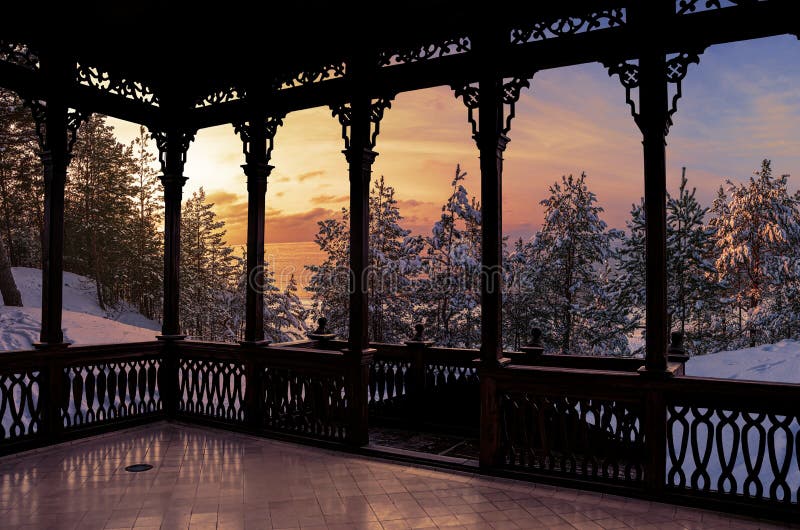 вид заката на замороженном снежном лесу, покрытом снежными корнями из деревянного балкона. деревянная галерея с открытым небом или