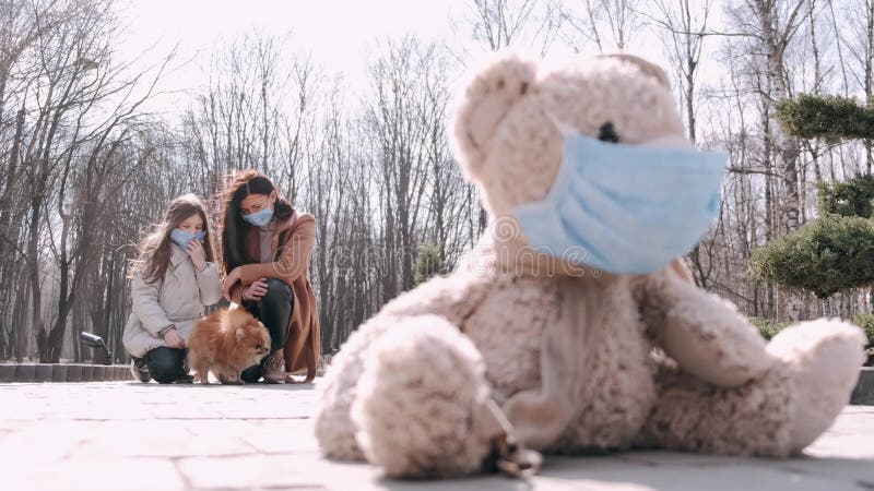 Вид игрушки в маске и мать и дочь в масках в парке видеоматериал