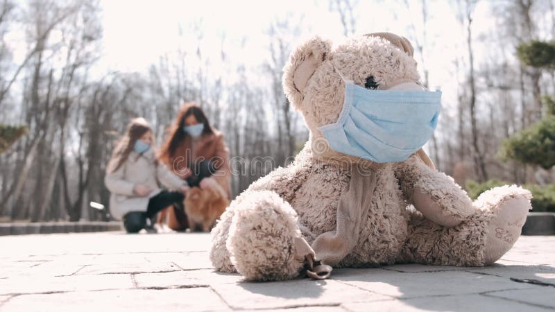Вид игрушки в маске и мать и дочь в масках в парке видеоматериал