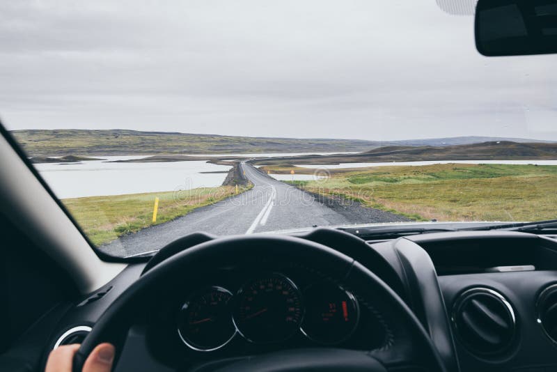 View from driver& x27;s seat over the road to Landmannalaugar, Iceland. Car, trip, national, park, skaftafell, mountain, peak, wheel, hand, windshield, north, asphalt, ring, tour, tourist, destination, hike, cover, duster, rental, auto, vehicle, speed, approach, vatnajokull, largest, mass, europe, pole, blue, sky, summer, coastal, south, steer, hold, bridge, limit, drivers. View from driver& x27;s seat over the road to Landmannalaugar, Iceland. Car, trip, national, park, skaftafell, mountain, peak, wheel, hand, windshield, north, asphalt, ring, tour, tourist, destination, hike, cover, duster, rental, auto, vehicle, speed, approach, vatnajokull, largest, mass, europe, pole, blue, sky, summer, coastal, south, steer, hold, bridge, limit, drivers