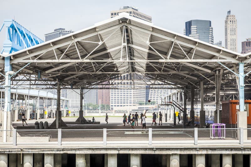 New York CIty, USA - July 7, 2018; View of pier 2 in Brooklyn with unrecognizable people playing basketball during summer daytime on July 7, 2018 in New York CIty. New York CIty, USA - July 7, 2018; View of pier 2 in Brooklyn with unrecognizable people playing basketball during summer daytime on July 7, 2018 in New York CIty