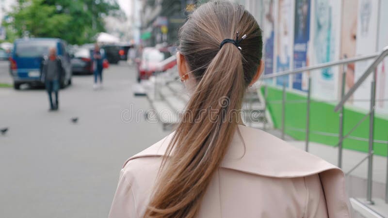 вид на кавказскую молодую деловую женщину, идущую по улице в центре большого города. вне. задний вид
