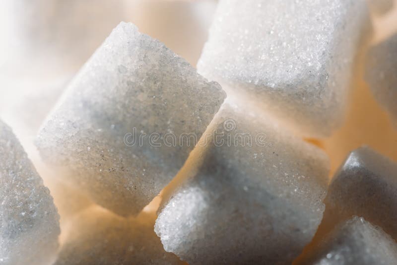 Close up view of lightened refined white sugar cubes. Close up view of lightened refined white sugar cubes