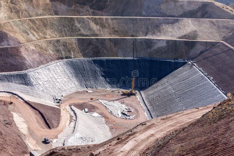 View of the industrial mine waste dam tailing dam. A tailings dam is typically an earth-fill embankment dam used to store byproducts of mining operations after separating the ore from the gangue. View of the industrial mine waste dam tailing dam. A tailings dam is typically an earth-fill embankment dam used to store byproducts of mining operations after separating the ore from the gangue.