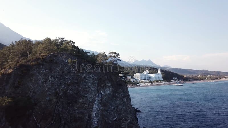 Вид с воздуха на seashore с роскошной гостиницей с предпосылкой леса и гор и голубым небом видео Красивая верхняя часть лета стоковые фотографии rf Вид с воздуха на seashore с роскошной гостиницей с предпосылкой леса и гор и голубым небом видео Красивая верхняя часть лета стоковые фотографии rf