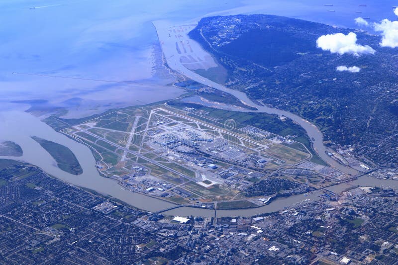 Aerial photo of Vancouver International Airport on Sea Island at Richmond in the Fraser River Delta with University of British Columbia campus in the background, Pacific Coast, Vancouver, BC, Canada. Aerial photo of Vancouver International Airport on Sea Island at Richmond in the Fraser River Delta with University of British Columbia campus in the background, Pacific Coast, Vancouver, BC, Canada.