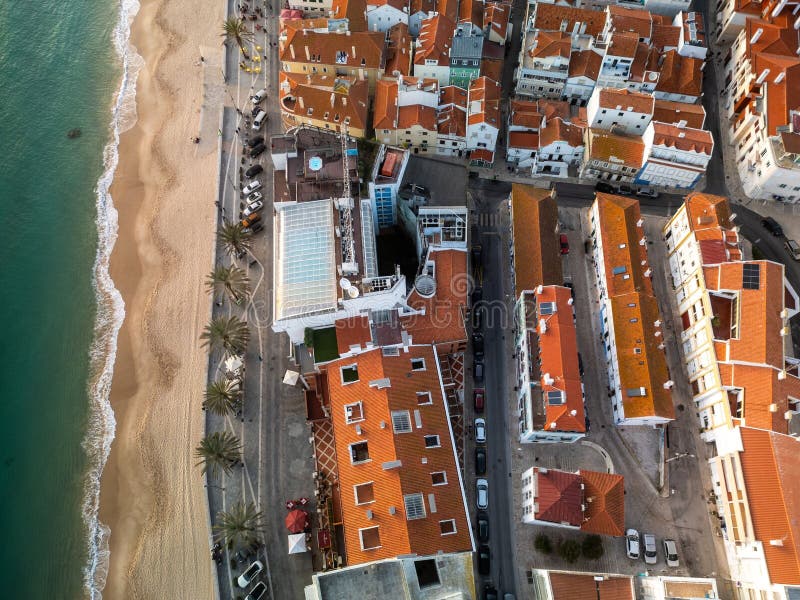 Вид с воздуха на прибрежный город с красными крышами и пляж в Sesimbra Portugal стоковая фотография rf