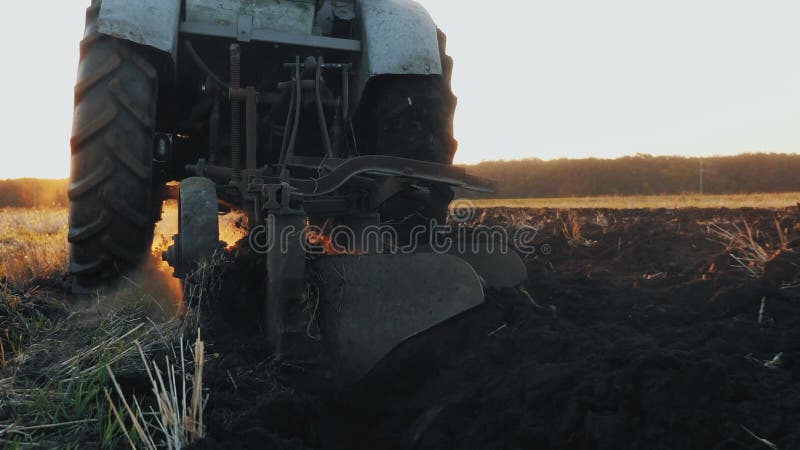 Вид сзади старого серого трактора с бороной