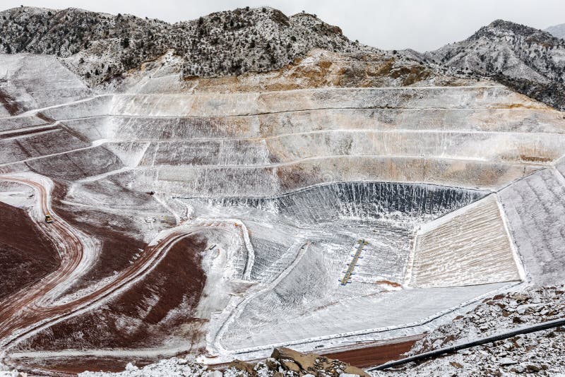 View of the tailings dam or waste dam construction and sealing membrane assembly for mining plant with snowy weather. View of the tailings dam or waste dam construction and sealing membrane assembly for mining plant with snowy weather.