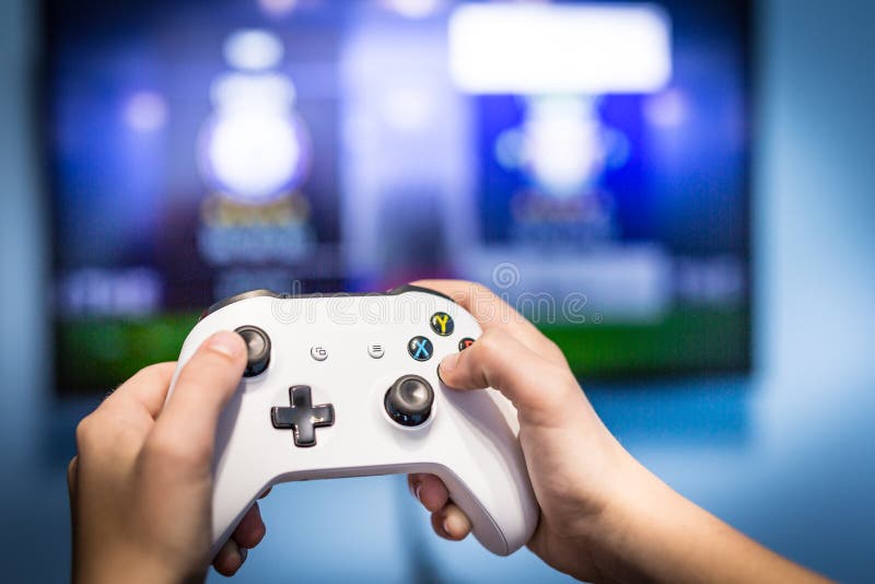 Видео- игра и gamer потехи игры игры по телевизору держа консоль игр-пусковой площадки и регулятора видео- играя и наслаждаясь с стоковые изображения rf
