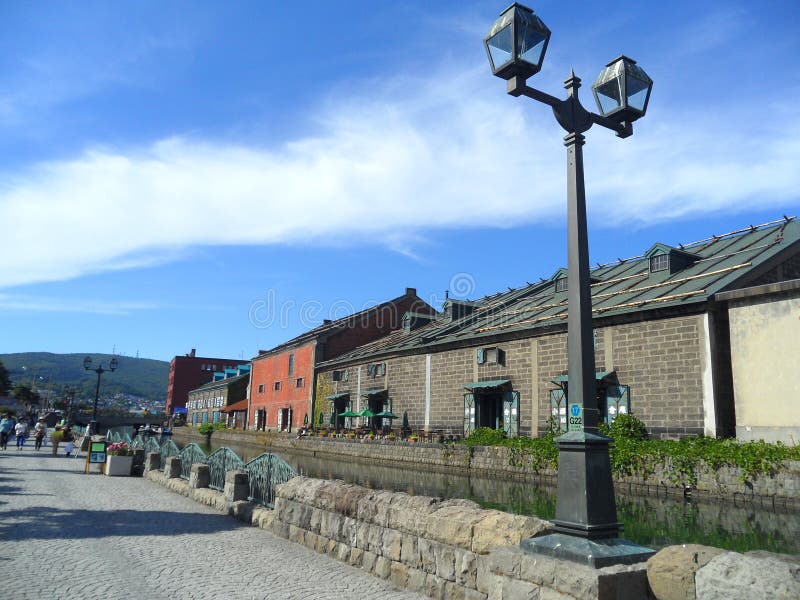 Винтажный уличный фонарь и старый склад вдоль канала Otaru в Японии стоковое фото Винтажный уличный фонарь и старый склад вдоль канала Otaru в Японии стоковое фото