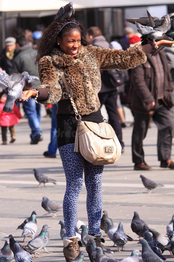 Tourist girl with pigeons at the piazza duomo in milan, italy. For a small amount of money you can have your picture taken with the pigeans at the piazza duomo, a big tourist attraction. Taken on 26-2-2011. Tourist girl with pigeons at the piazza duomo in milan, italy. For a small amount of money you can have your picture taken with the pigeans at the piazza duomo, a big tourist attraction. Taken on 26-2-2011.