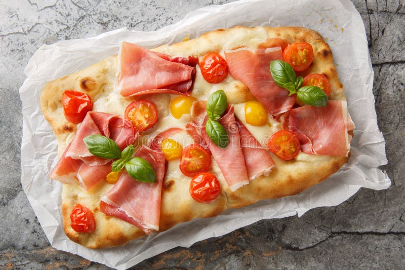 Вкусная пицца pinsa romana с томатной смесью сыра моцарелла и базилик на пергаменте. горизонтальное верхнее окно стоковая фотография rf