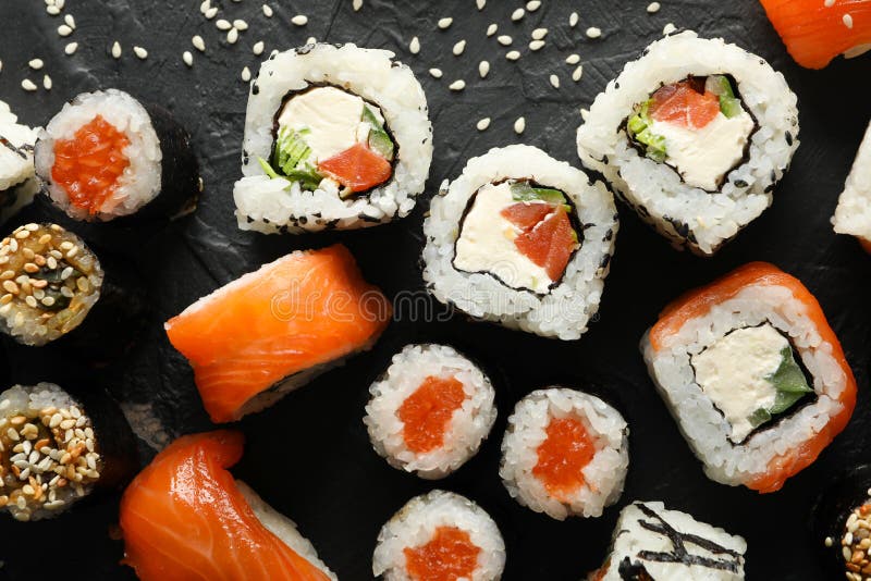 Вкусные роллы суши на черном фоне. Японская кухня стоковые изображения rf