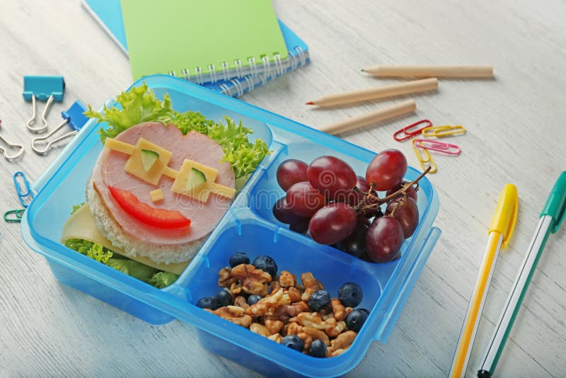 Вкусные сандвич и плодоовощи в коробке для завтрака и канцелярских принадлежностях стоковая фотография Вкусные сандвич и плодоовощи в коробке для завтрака и канцелярских принадлежностях стоковая фотография
