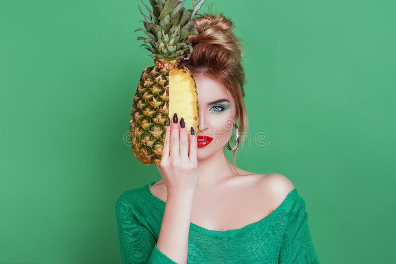 Вкусные тропические плодоовощи! Привлекательная сексуальная женщина при красивый состав держа свежий сочный ананас и смотря кулач стоковая фотография Вкусные тропические плодоовощи! Привлекательная сексуальная женщина при красивый состав держа свежий сочный ананас и смотря кулач стоковая фотография