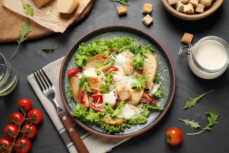 Вкусный свежий салат Цезаря на черном столе, плоский стоковая фотография rf