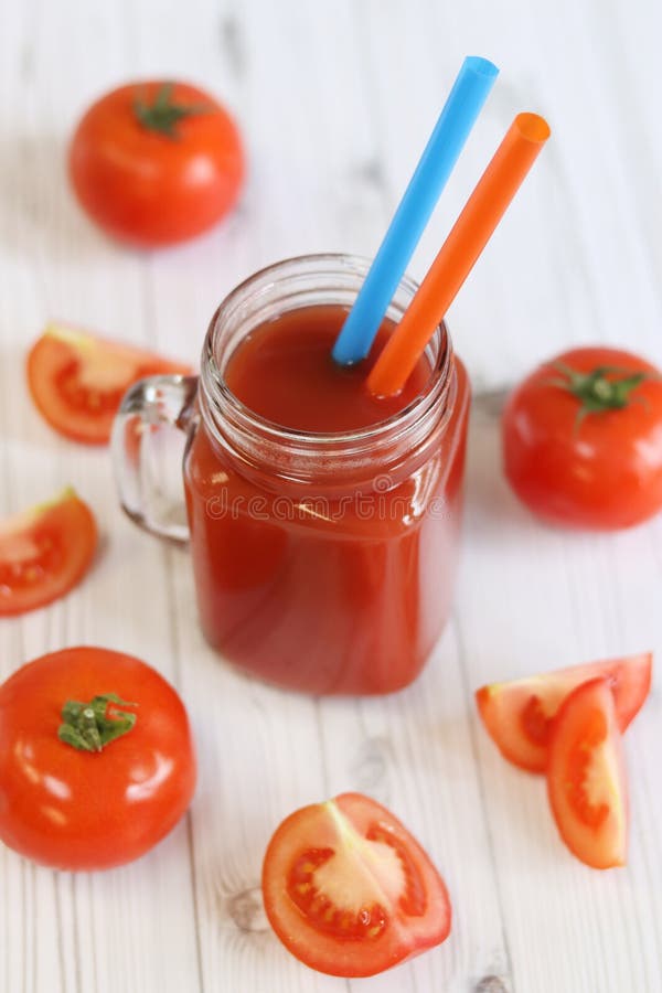 Вкусный томатный сок в стакане и свежие помидоры на светло-сером столе стоковое изображение rf