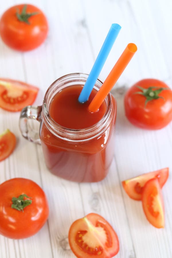 Вкусный томатный сок в стакане и свежие помидоры на светло-сером столе стоковая фотография