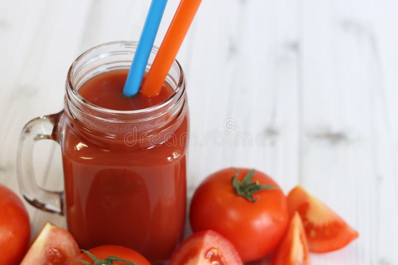 Вкусный томатный сок в стакане и свежие помидоры на светло-сером столе стоковое фото rf