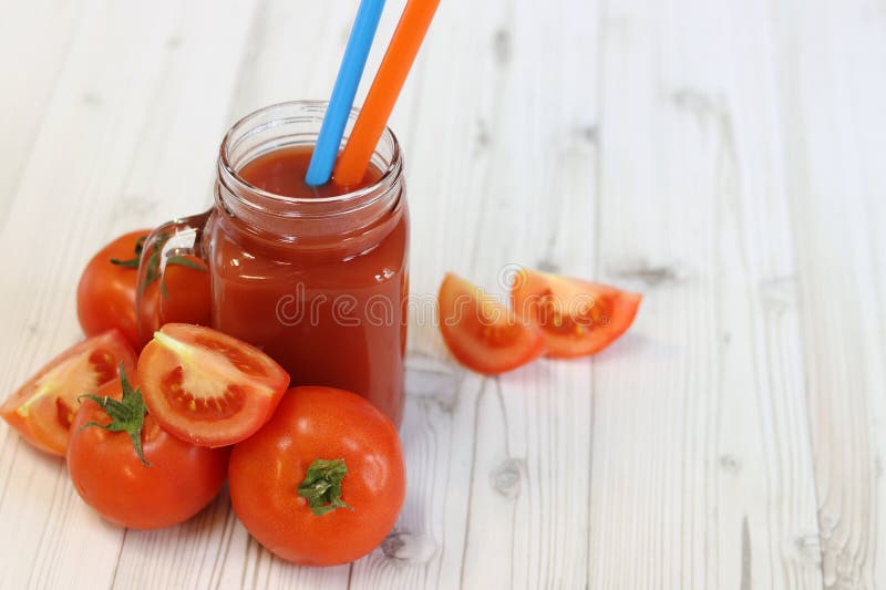 Вкусный томатный сок в стакане и свежие помидоры на светло-сером столе стоковое изображение rf