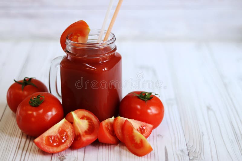 Вкусный томатный сок в стакане и свежие помидоры на светло-сером столе стоковая фотография