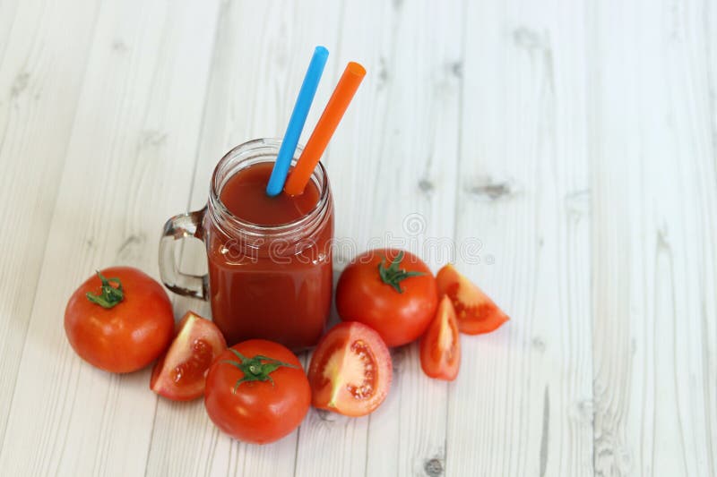 Вкусный томатный сок в стакане и свежие помидоры на светло-сером столе стоковое изображение rf