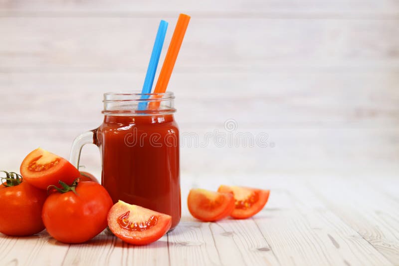 Вкусный томатный сок в стакане и свежие помидоры на светло-сером столе стоковые изображения