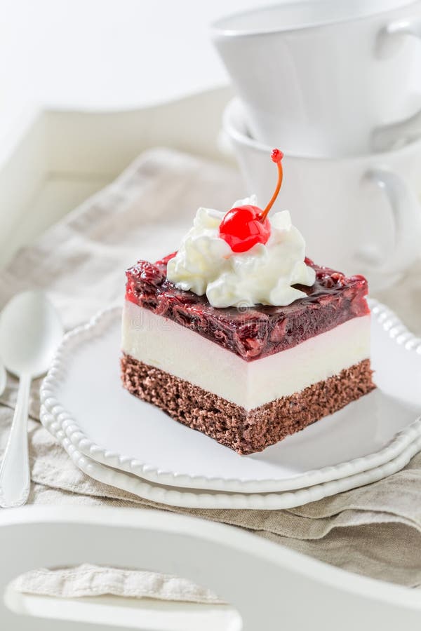 Вкусный торт вишни студня с сливк на белой плите стоковые фото
