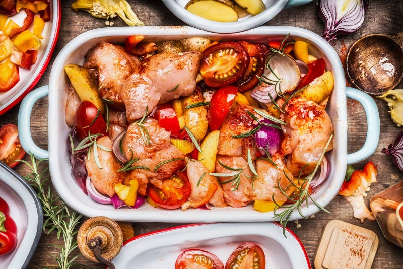 Вкусный цыпленок с красочными овощами и красной сладостной паприкой в сотейнике, подготовке на деревенской деревянной предпосылке стоковые фото