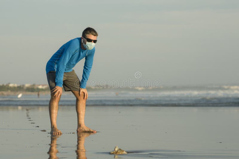 Вместить тренировки нового нормального пляжа бегать молодая и привлекательный мужчина в лицевого лоскута гермошлема дыхание устал стоковая фотография