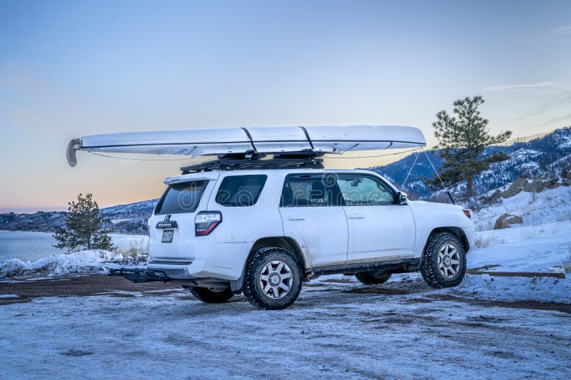 внедорожник toyota 4runner с экспедиционным каноэ на крыше стойки зимние пейзажи на берегу стоковая фотография
