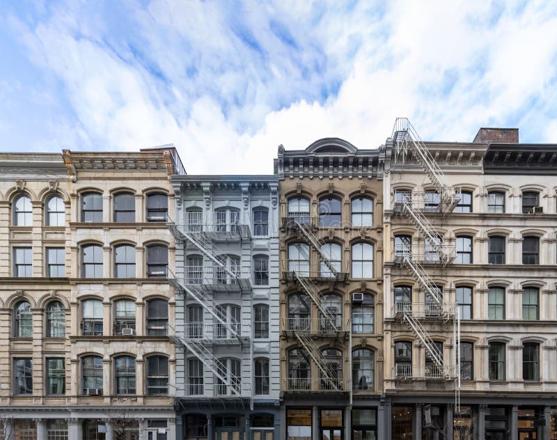 Внешний взгляд старых жилых домов в районе SoHo Манхэттена в Нью-Йорке с пустым голубым небом стоковое фото Внешний взгляд старых жилых домов в районе SoHo Манхэттена в Нью-Йорке с пустым голубым небом стоковое фото