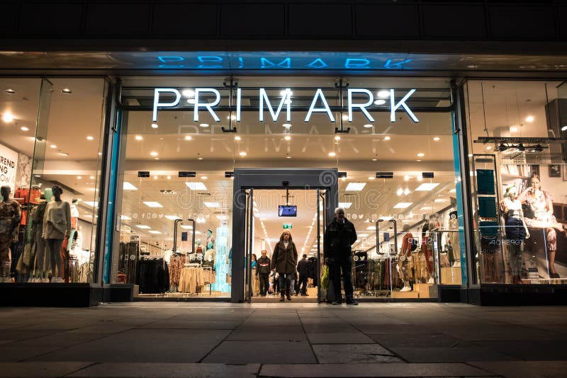 Внешняя снимок ночи загоренного входа в магазин одежды primark моды стоковое фото