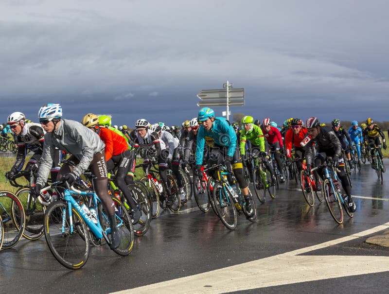 Cernay-la-Ville, France - March 5, 2017: The Belgian cyclist Laurens De Vreese of Astana Team riding in the peloton on a wet road during the first stage of Paris-Nice on 5 March, 2017. Cernay-la-Ville, France - March 5, 2017: The Belgian cyclist Laurens De Vreese of Astana Team riding in the peloton on a wet road during the first stage of Paris-Nice on 5 March, 2017.