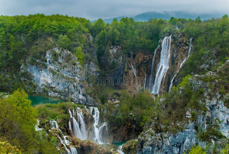 Scenic view of cascading waterfalls in forested mountains. Scenic view of cascading waterfalls in forested mountains.