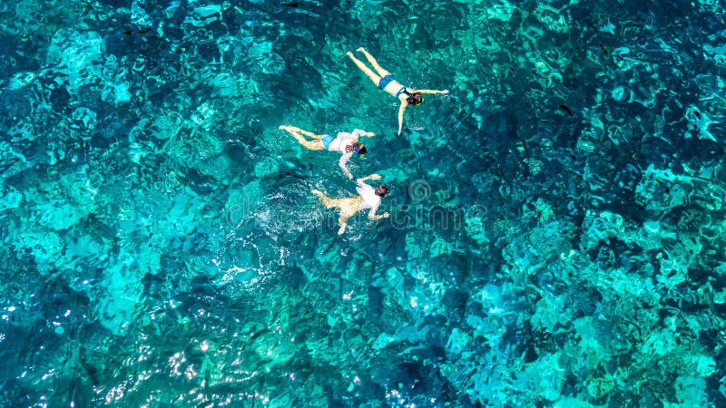 Воздушный взгляд сверху семьи сверху, матери и snorkelers детей плавая в яс стоковые изображения Воздушный взгляд сверху семьи сверху, матери и snorkelers детей плавая в яс стоковые изображения
